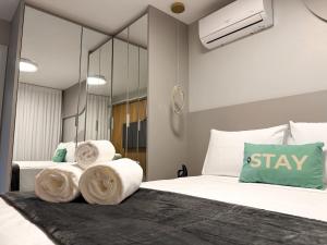 a bedroom with two beds with towels and a mirror at STAY ID Vida Urbana in Goiânia