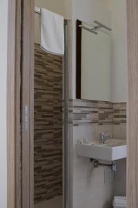 un bagno con lavandino e specchio di La Piazzetta Affittacamere a Ghilarza