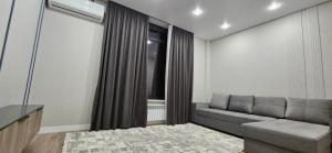 a living room with a couch and a window at Сдаётся квартира для иностранцев in Taraz