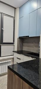 a kitchen with a black counter top and a window at Сдаётся квартира для иностранцев in Taraz