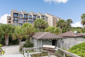 a building with palm trees in front of a house at Oceanfront 3 Bedrooom BeachWalker Condo in Amelia Island