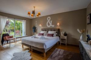 une chambre avec un grand lit et une grande fenêtre dans l'établissement la villa des temps modernes, à Trégastel