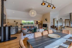 une salle à manger et un salon avec une table et des chaises dans l'établissement la villa des temps modernes, à Trégastel