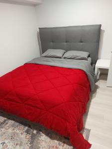 a red comforter on a bed in a bedroom at Dunique unique home in Winnipeg