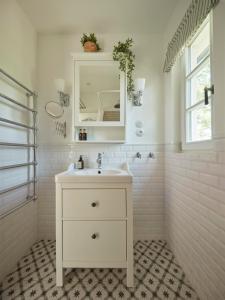 a white bathroom with a sink and a mirror at Nad svatým Kiliánem  +27 photos