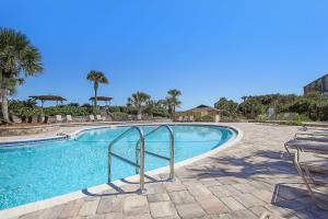 a large swimming pool with chairs and trees and a blue sky at Oceanfront 2 Bedrooom with sleeping loft in Franklintown