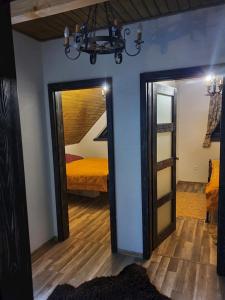 Una habitación con un dormitorio con una cama y un espejo. en Tri chalúpky na Mýte, en Mýto pod Ďumbierom
