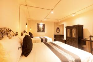 a bedroom with two beds and a large mirror at Casa de los Frailes in Oaxaca City +87 photos