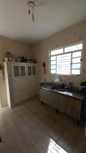 a kitchen with a sink and a window at Casa do Kazu in Águas da Prata