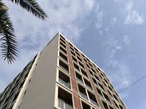 a tall white building with the sky in the background at Orchid 001Airport view55 TVCoffee maker in Pune