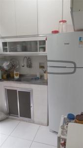 里约热内卢Quarto da Nubia no Coração da Lapa的厨房配有白色橱柜和白色冰箱