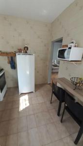 a kitchen with a refrigerator and a microwave at Casa do Kazu in Águas da Prata