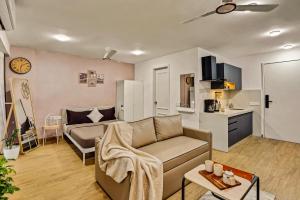 a living room with a couch and a kitchen at Orchid 001Airport view55 TVCoffee maker in Pune