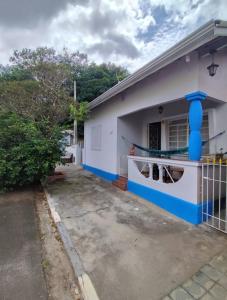 a white and blue house with a parking lot at Casa do Kazu in Águas da Prata