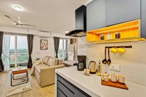 a kitchen with a counter top and a living room at Orchid 001Airport view55 TVCoffee maker in Pune +17 photos