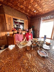 two women sitting at a table with food at Luxury freedom group of houseboats in Srinagar