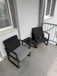 two chairs and a table on a balcony at Tolles Apartment in Magdeburg-Salbke mit Balkon und WiFi in Magdeburg