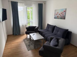 a living room with a couch and two chairs and a table at Tolles Apartment in Magdeburg-Salbke mit Balkon und WiFi in Magdeburg