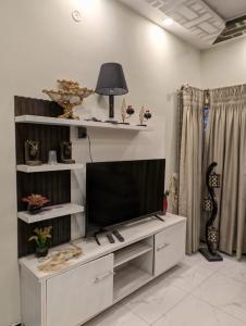 a living room with a television on a white entertainment center at Dream house  +7 photos