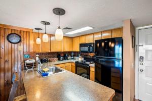 a kitchen with wooden cabinets and a black refrigerator at Mountain Top View in Pittman Center