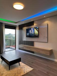a living room with a flat screen tv on the wall at Behomu Apartments Kampala in Kira +19 photos