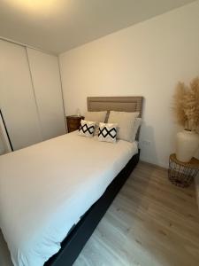 a bedroom with a large white bed with two pillows at Malakoff - 3 pièces avec terrasse in Malakoff