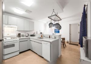 a white kitchen with a sink and a stove at Super Spacious 2 bedroom Clinton Hill Garden Duplex in Brooklyn