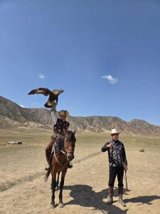 a man riding a horse with a bird on his shoulder at "Kamchybek Ata" guest house B&B in Tërt-Kul'