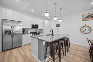 eine Küche mit weißen Schränken und eine Kücheninsel mit Barhockern in der Unterkunft The Grand Retreat - 18 Guests in Harrisburg Junction + 41 Fotos