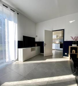 a living room with a television and a large window at La Petite Vitesse in La Flèche