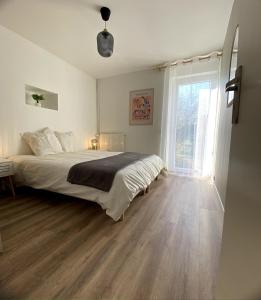 a bedroom with a bed and a large window at La Petite Vitesse in La Flèche