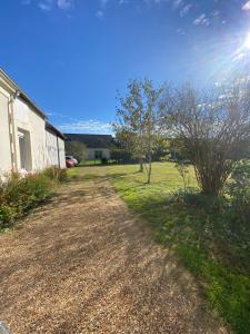 a dirt road next to a building and trees at La Petite Vitesse in La Flèche