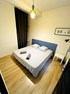 a bedroom with a white bed with a blue headboard at Le bureau du Maire in Bourg-lès-Valence