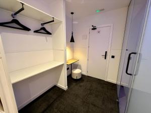 - un dressing avec des étagères blanches et une porte dans l'établissement Mucho Madrid, à Madrid