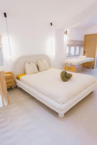 una camera da letto bianca con un letto grande e un tavolo di Sauna - Massage - Double Shower - Luxe in Romans a Romans-sur-Isère