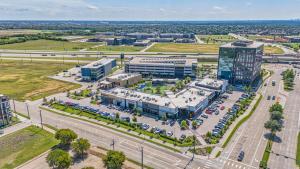 an aerial view of a building with a parking lot at Denizen Hotel in McKinney