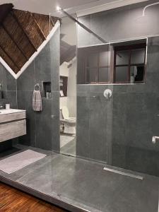 a bathroom with a glass shower and a sink at Mountain whispers in Hazyview