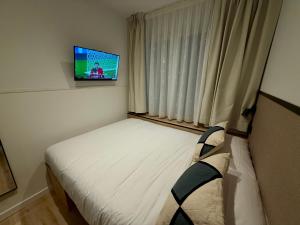 une petite chambre avec un lit et une télévision dans l'établissement Mucho Madrid, à Madrid 37 autres photos