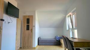 a room with a blue couch and a table and a window at Mazury Apartament/Dom z ogródkiem całoroczny przy jeziorze in Sędańsk