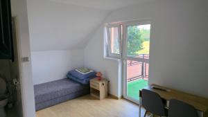 a small room with a bed and a window at Mazury Apartament/Dom z ogródkiem całoroczny przy jeziorze in Sędańsk