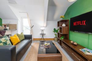 Una sala de estar con un sofá y un televisor. en Llangefni Town Centre 3 Bed Apt & Free Parking, en Llangefni