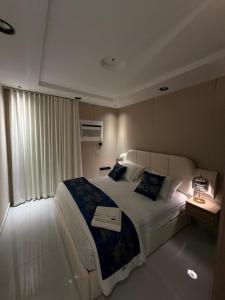 ein Schlafzimmer mit einem großen Bett mit einem Buch darauf in der Unterkunft شقة فاخرة بحي الزهراء in Dschidda