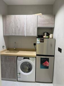 eine Küche mit einer Waschmaschine und einem Kühlschrank in der Unterkunft شقة فاخرة بحي الزهراء in Dschidda