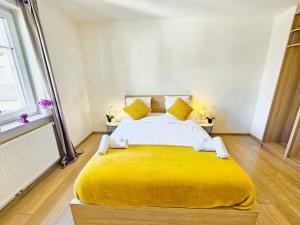 a bedroom with a large bed with a yellow blanket at Central&comfy 2BR Flat with parking in Luxembourg