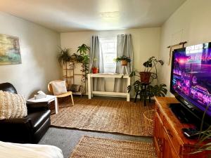 ein Wohnzimmer mit einem Flachbild-TV und ein Zimmer mit einem Sofa in der Unterkunft NookSide Nest Upstairs 2bedroom Suite King, Queen Kitchenette, Parking in Carleton Place