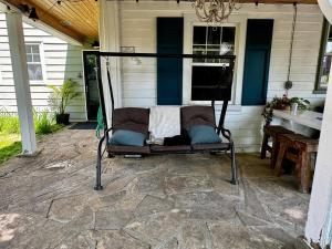 einen Stuhl auf einer Terrasse mit einem Tisch in der Unterkunft NookSide Nest Upstairs 2bedroom Suite King, Queen Kitchenette, Parking in Carleton Place