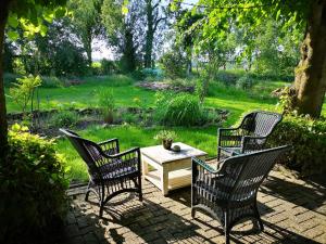 a patio with three chairs and a table in a yard at South African Room in Westbeemster