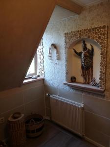 a bathroom with a window and a statue on a wall at South African Room in Westbeemster
