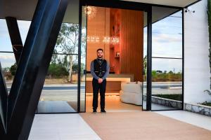 a man in a suit standing inside of a building at Farms Hotel in Coribe