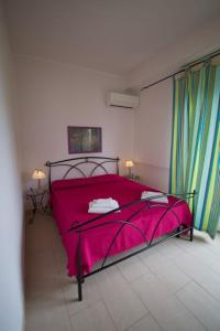 a bedroom with a bed with a pink blanket at Orizzonte Mare in Fontane Bianche